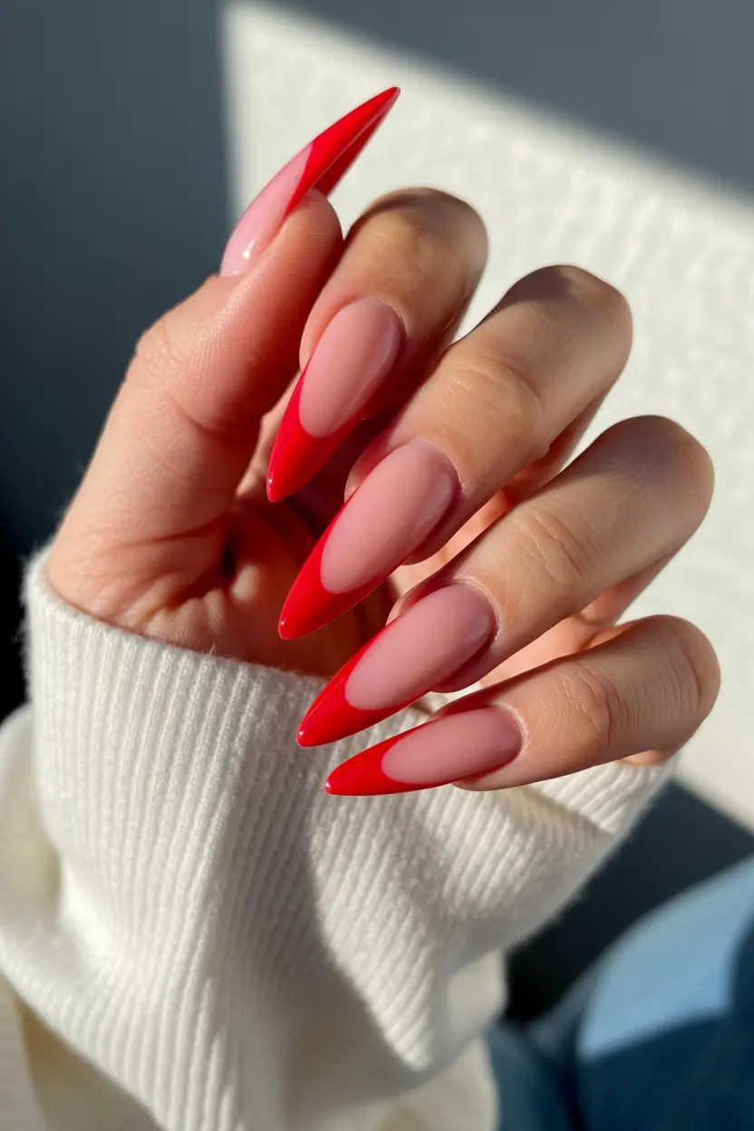 spring to summer season nails color ideas 2026 Sharp Red Stiletto French Tips for a Dramatic Modern Finish