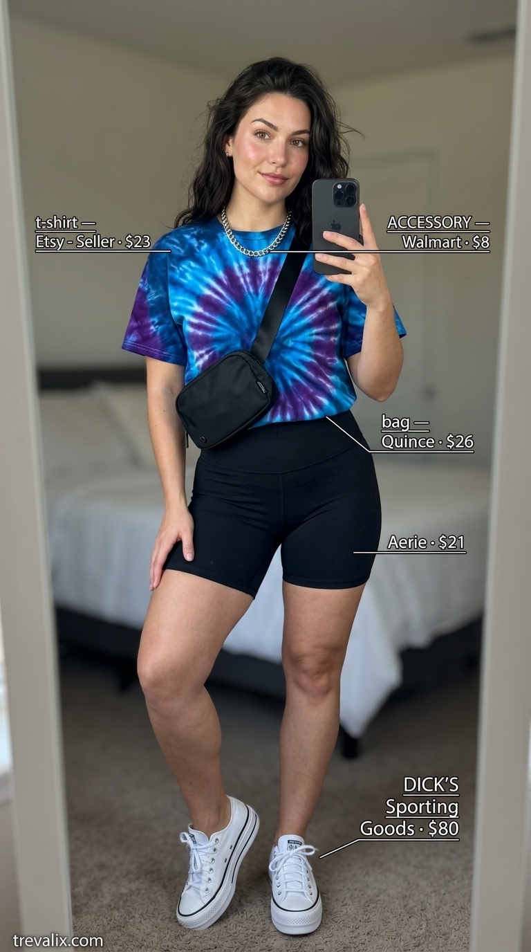 Trendy summer t-shirt outfit for women 2026: Tie-dye tee, biker shorts, chunky sneakers, and crossbody bag.