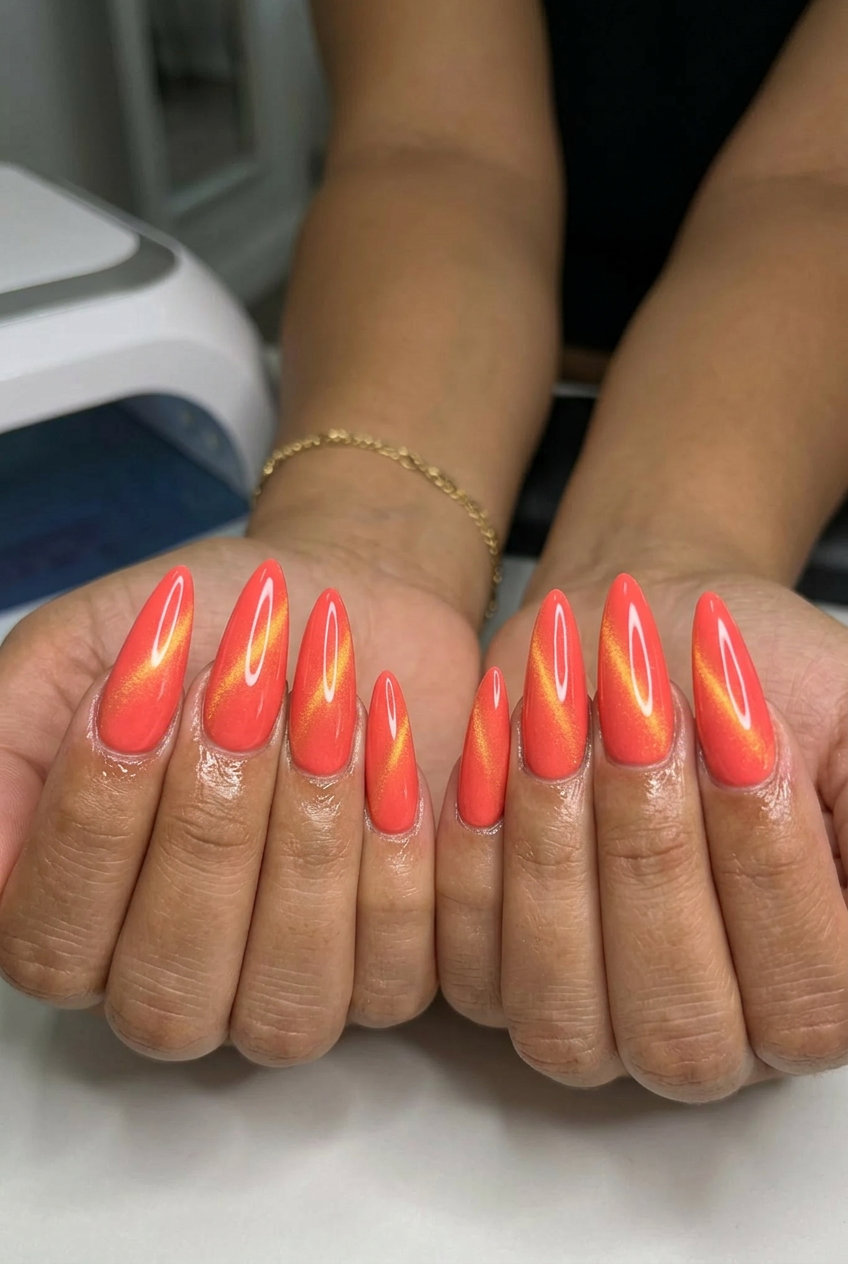 Cute summer nails 2026: Bright coral cat-eye stiletto for parties and summer events.