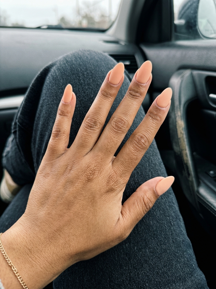 Medium almond acrylic nails in soft peach fuzz with a velvet matte finish. Sophisticated for events and date nights. Simple summer acrylic nail designs 2026.