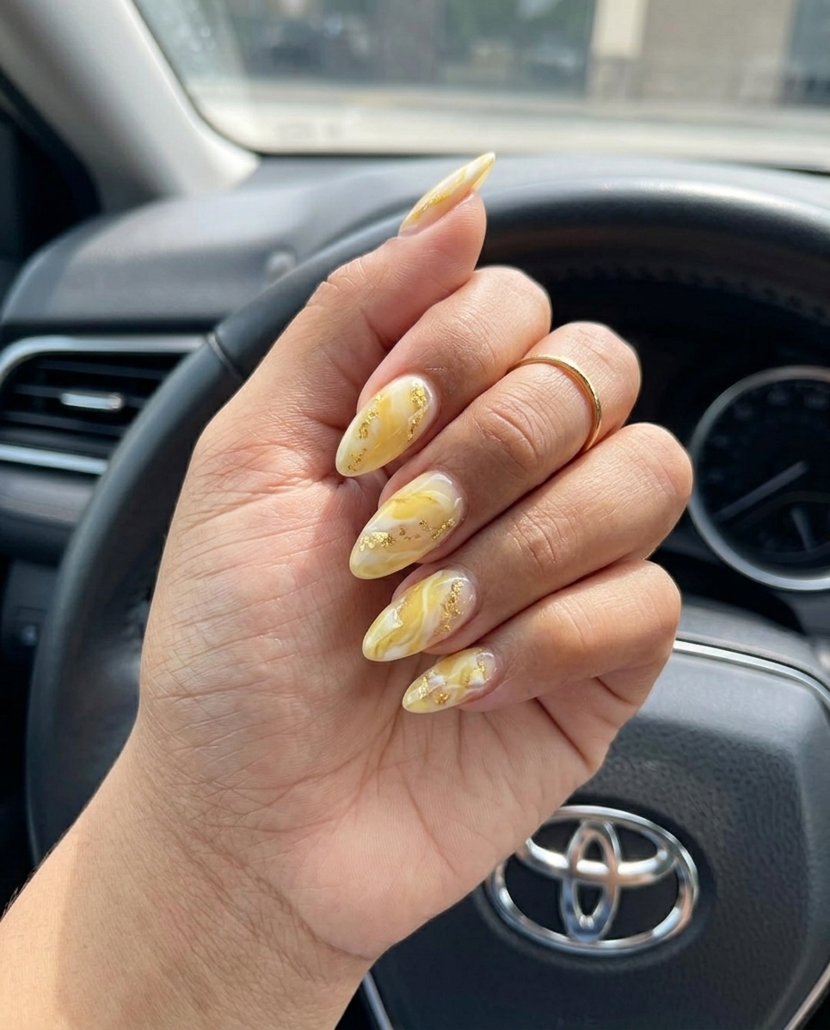 Yellow Marble Gold Flake Nails 2026: Elegant Summer Event Yellow marble with gold flakes on almond nails for a sophisticated summer wedding guest look in 2026.