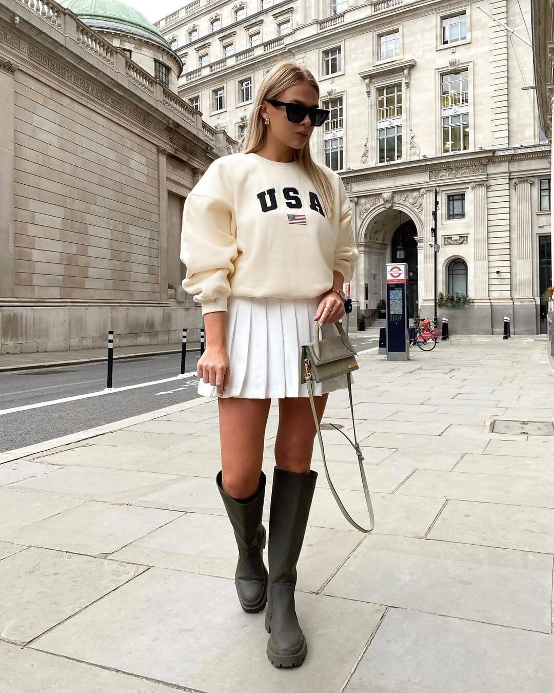 White Pleated Mini Skirt with Graphic Sweatshirt and Tall Boots — Pleated Skirt Outfits 2027