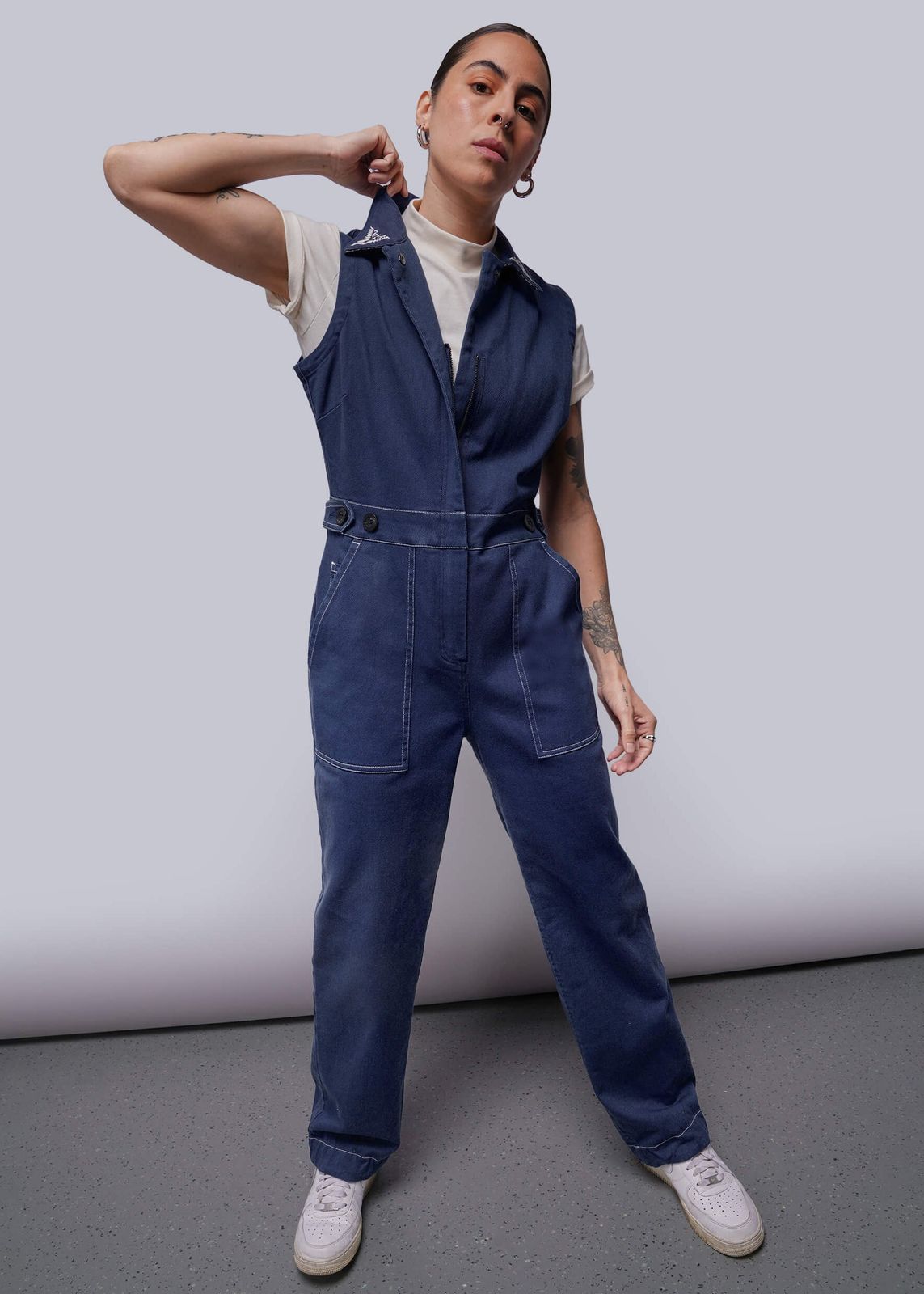 Sleeveless Blue Denim Jumpsuit with Contrast Stitching and White Sneakers Sleeveless Blue Denim Jumpsuit with Contrast Stitching and White Sneakers — Overalls 2027