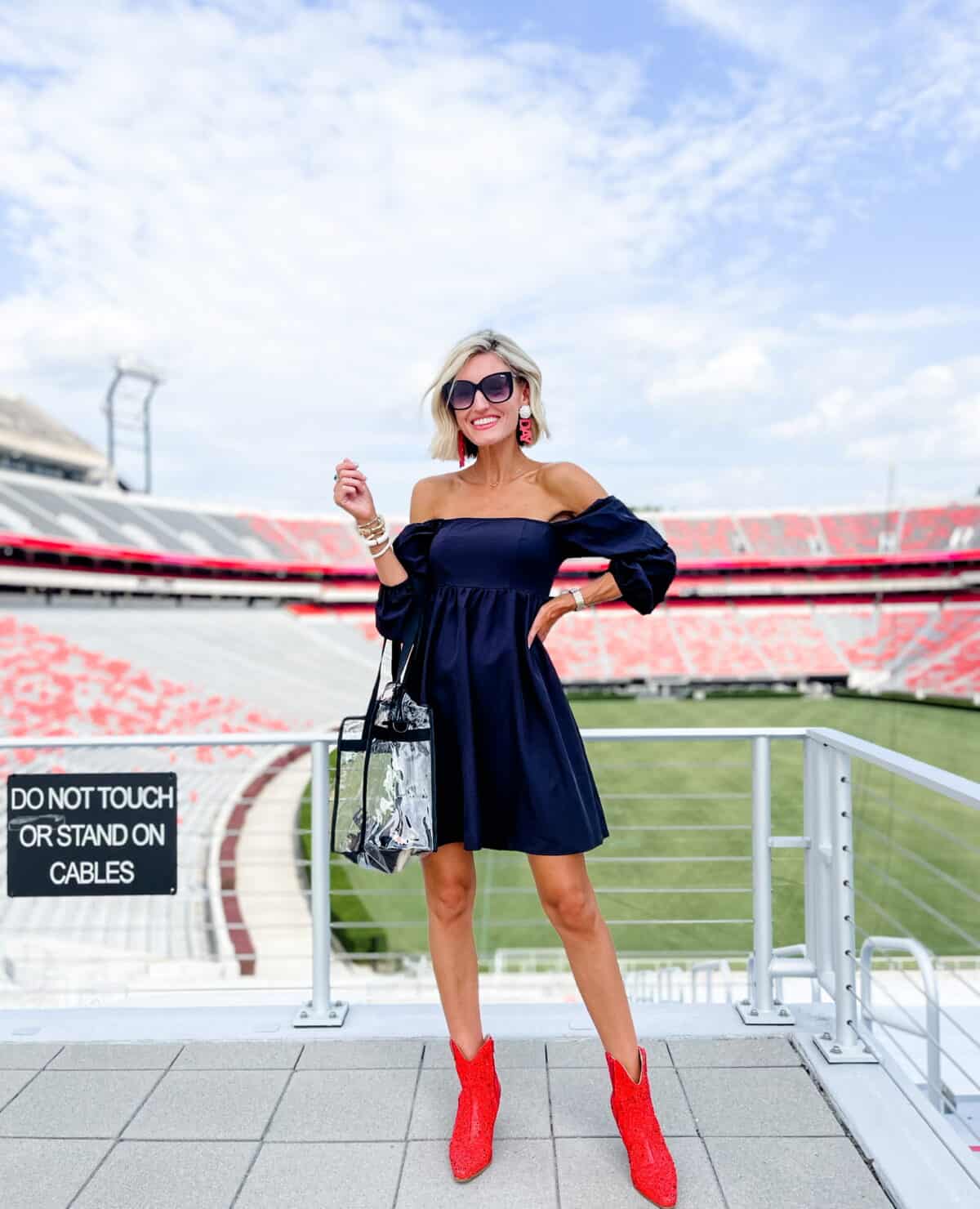 Bold Statement: Navy Off-the-Shoulder Dress with Red Boots — College Game Day Outfits 2026