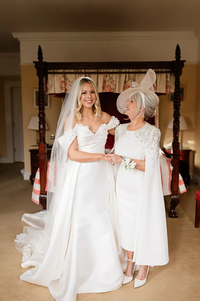 White Dress with Embellished Cape Overlay and Wide-Brimmed Hat White Dress with Embellished Cape Overlay and Wide-Brimmed Hat — Grandmother of the Bride Outfits 2027