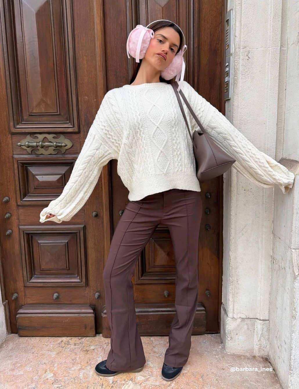 Oversized Cable-Knit Sweater with Flared Trousers and Pink Earmuffs — Winter Western Outfits 2027