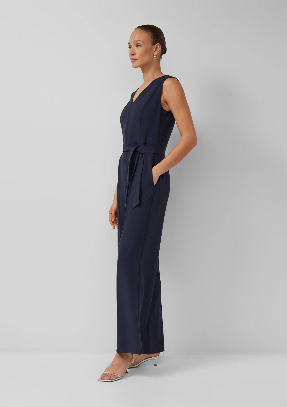 Navy Blue Tie-Belt Jumpsuit with Silver Heels for Smart Casual Navy Blue Tie-Belt Jumpsuit with Silver Heels for Smart Casual — Sleeveless Jumpsuit Outfits 2027