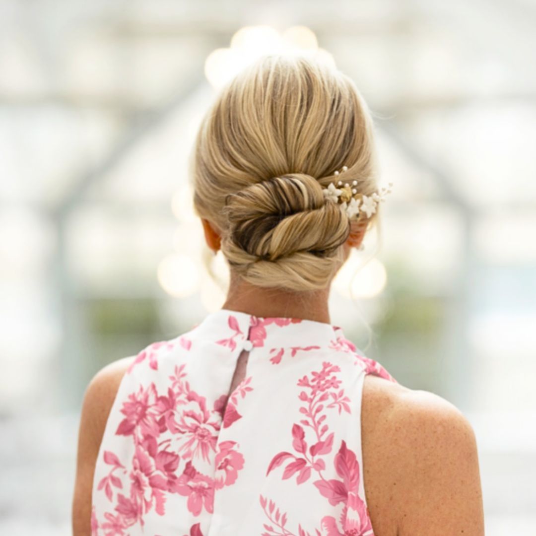 Low Twisted Bun With Floral Accessory Low Twisted Bun With Floral Accessory — Summer Updos 2027