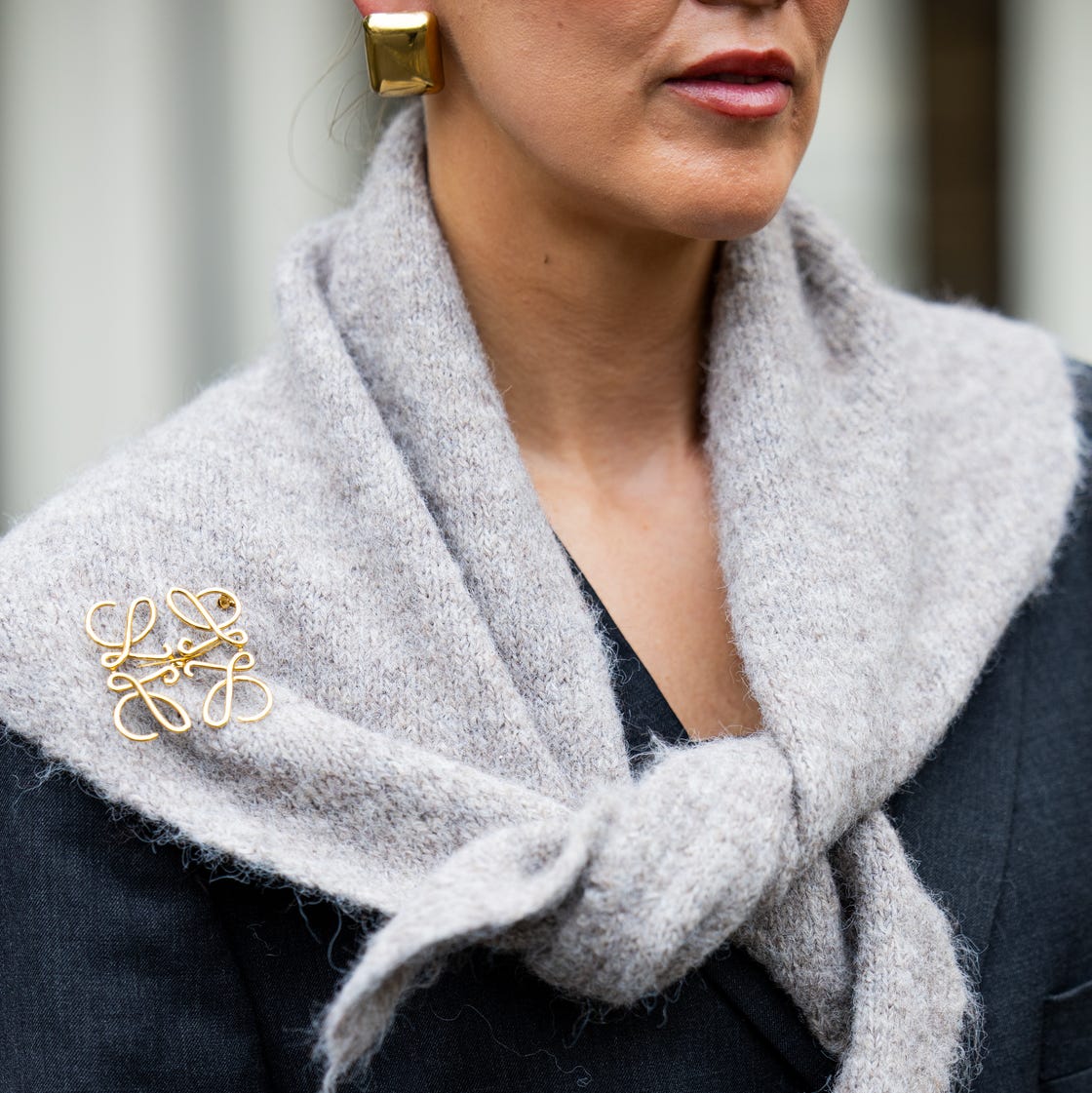 Scarf Accent: Gold Logo Brooch on a Grey Knit Scarf Scarf Accent: Gold Logo Brooch on a Grey Knit Scarf — Brooch Outfits 2027