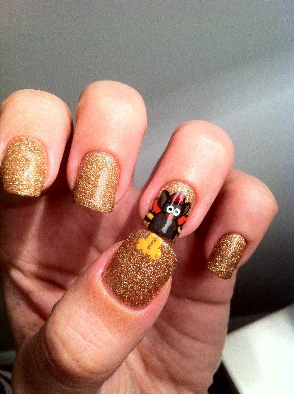 Gold Glitter with Matte Turkey Face — Simple Thanksgiving Nails 2026