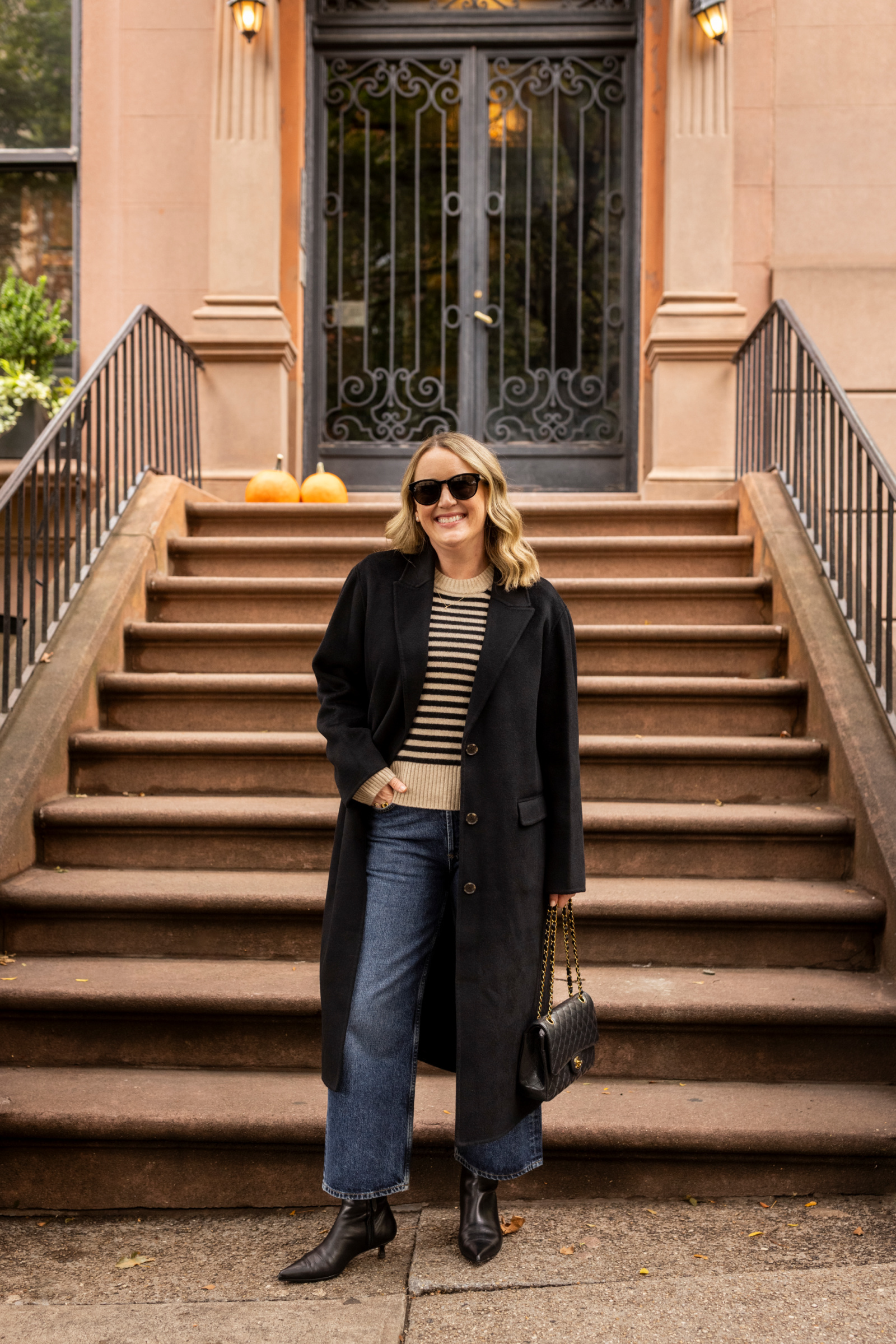 Black Long Coat Over Striped Knit And Wide-Leg Jeans Black Long Coat Over Striped Knit And Wide-Leg Jeans — Winter Dinner Outfits 2027