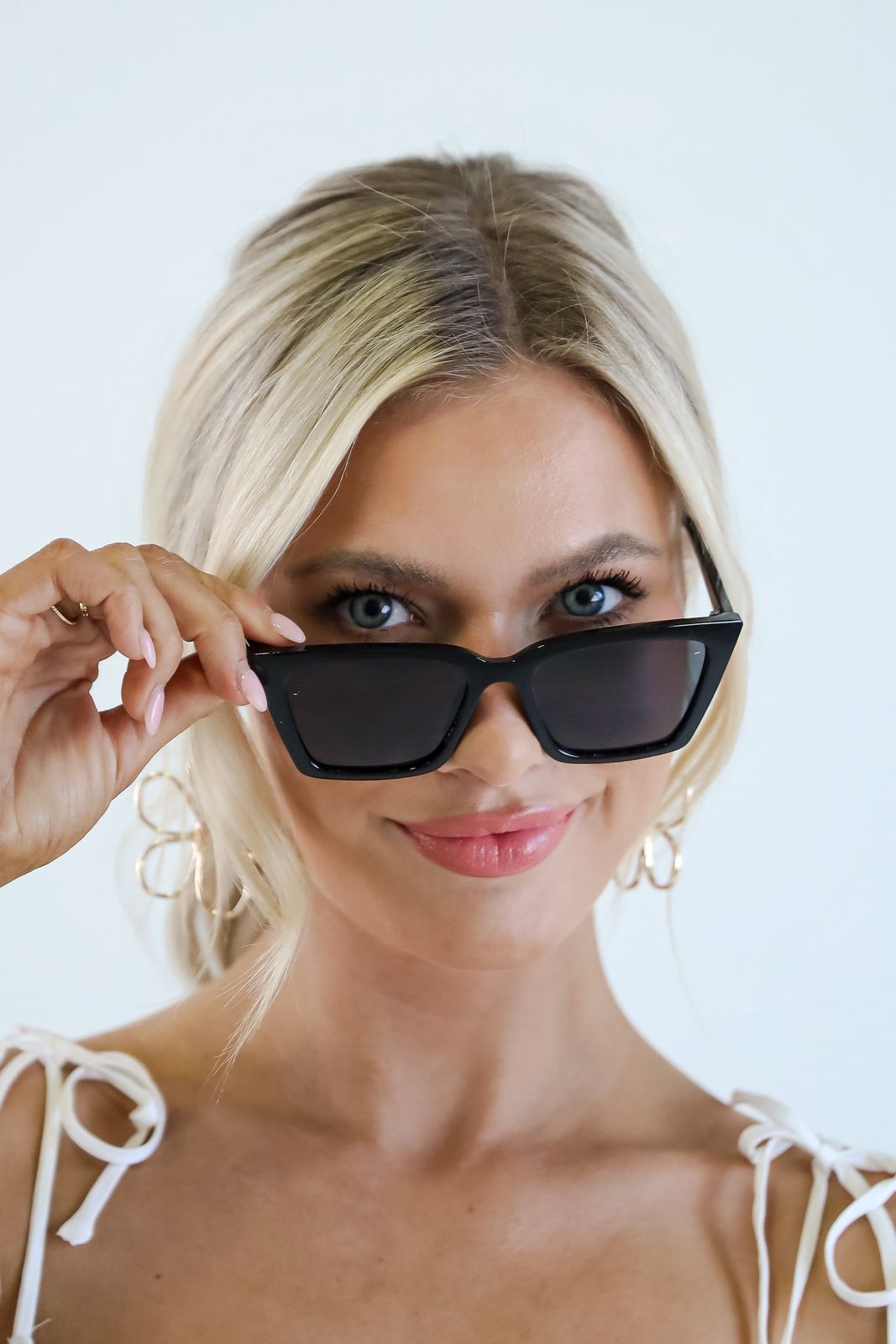 White Tie-Strap Top with Black Cat Eyes and Gold Hoops — Cat Eye Sunglasses Outfits 2027