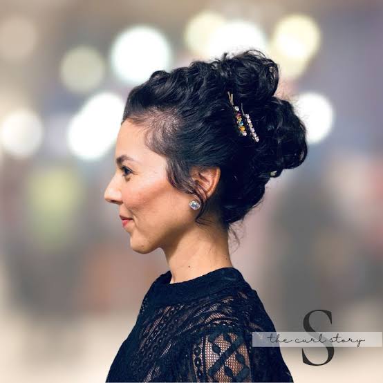 Textured High Bun with Wispy Bangs — Holiday Party Hairstyles 2026