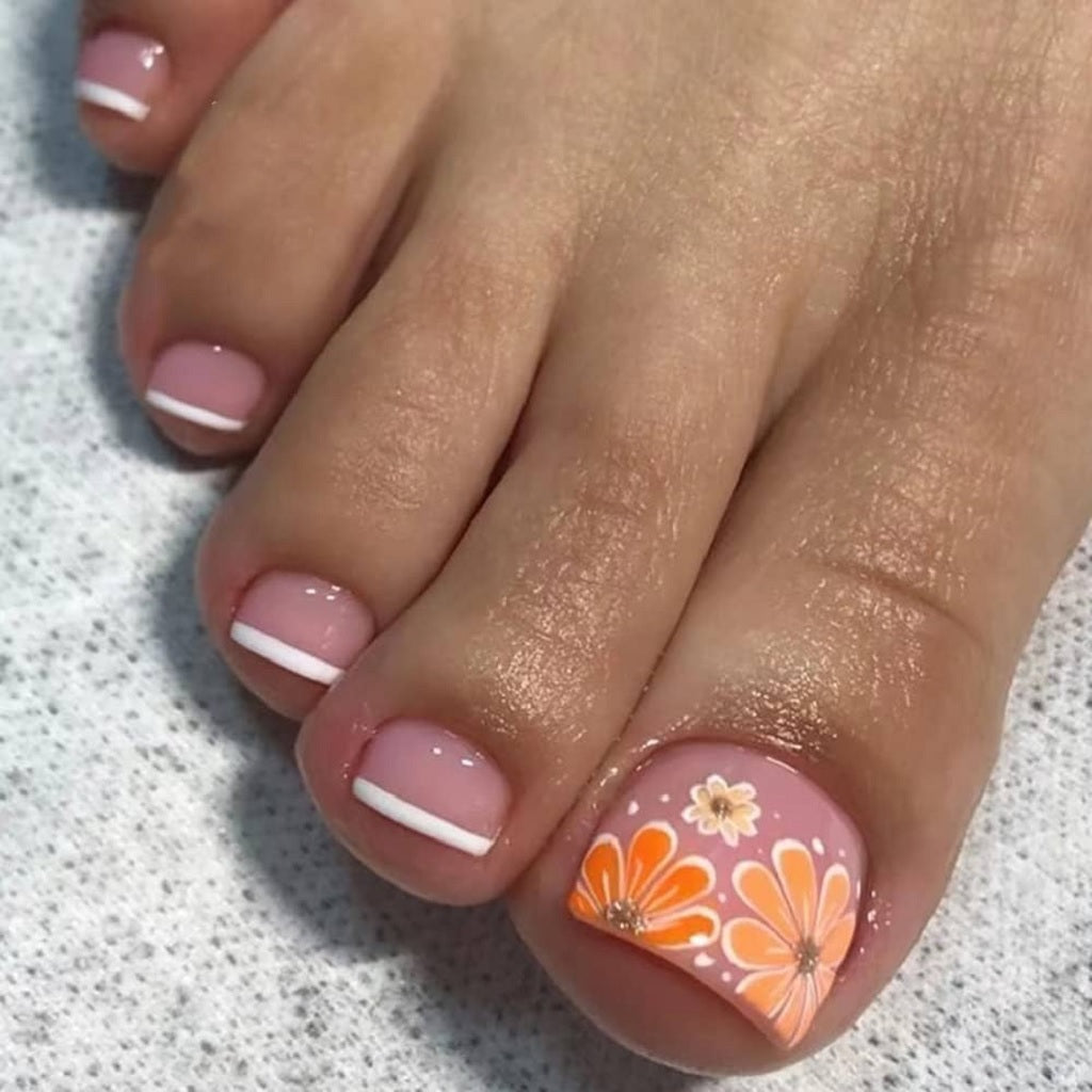 Close-Up Of One Foot Orange Floral Accent French Tip Toes Close-Up Of One Foot Orange Floral Accent French Tip Toes — Vacation Toe Nails 2027