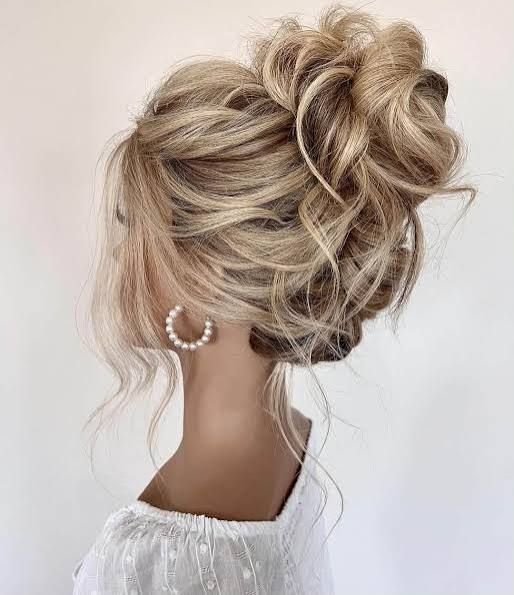 Messy High Bun With Loose Tendrils Messy High Bun With Loose Tendrils — Summer Updos 2027