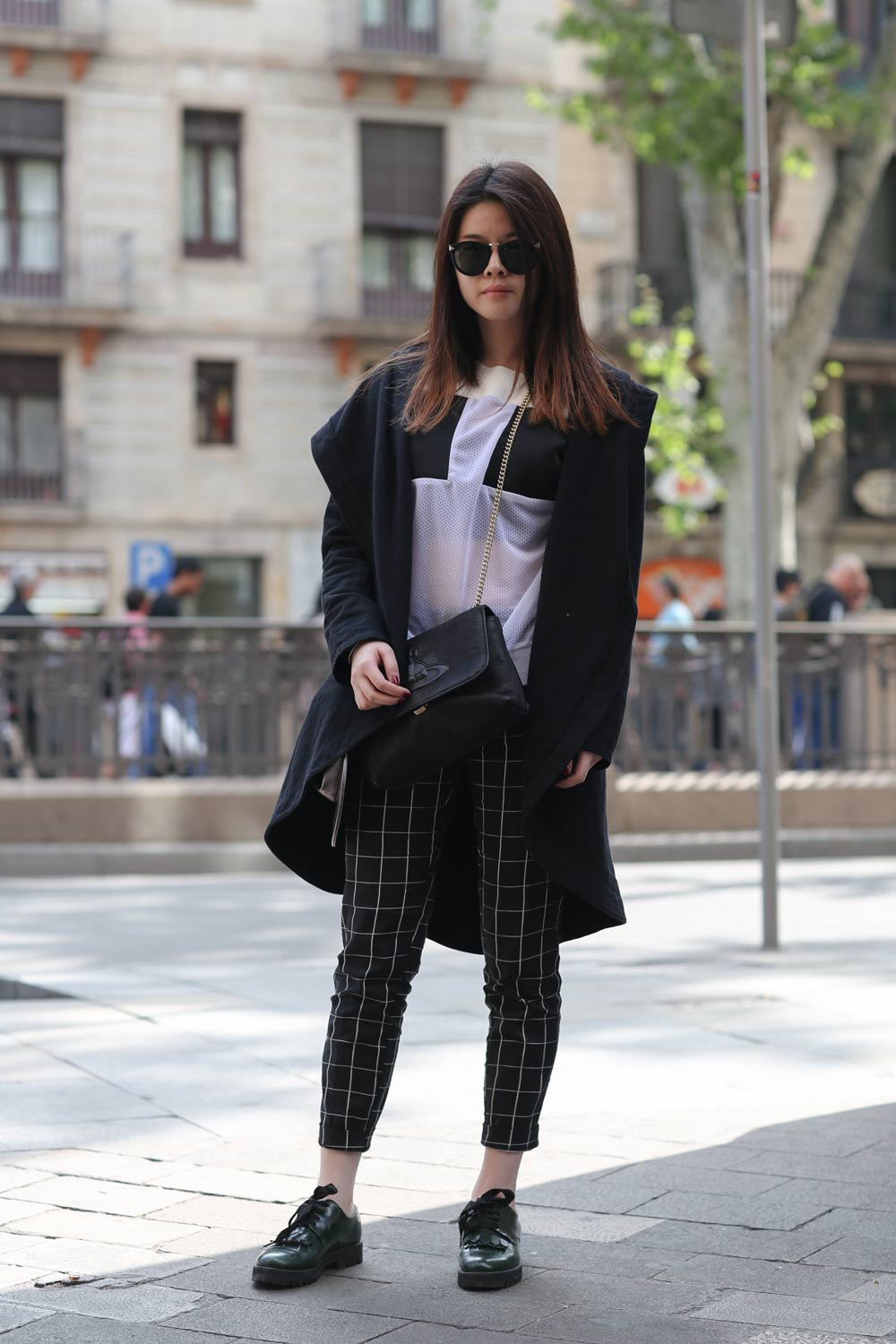 Grid-Print Trousers Under a Black Coat — Barcelona Outfits 2027