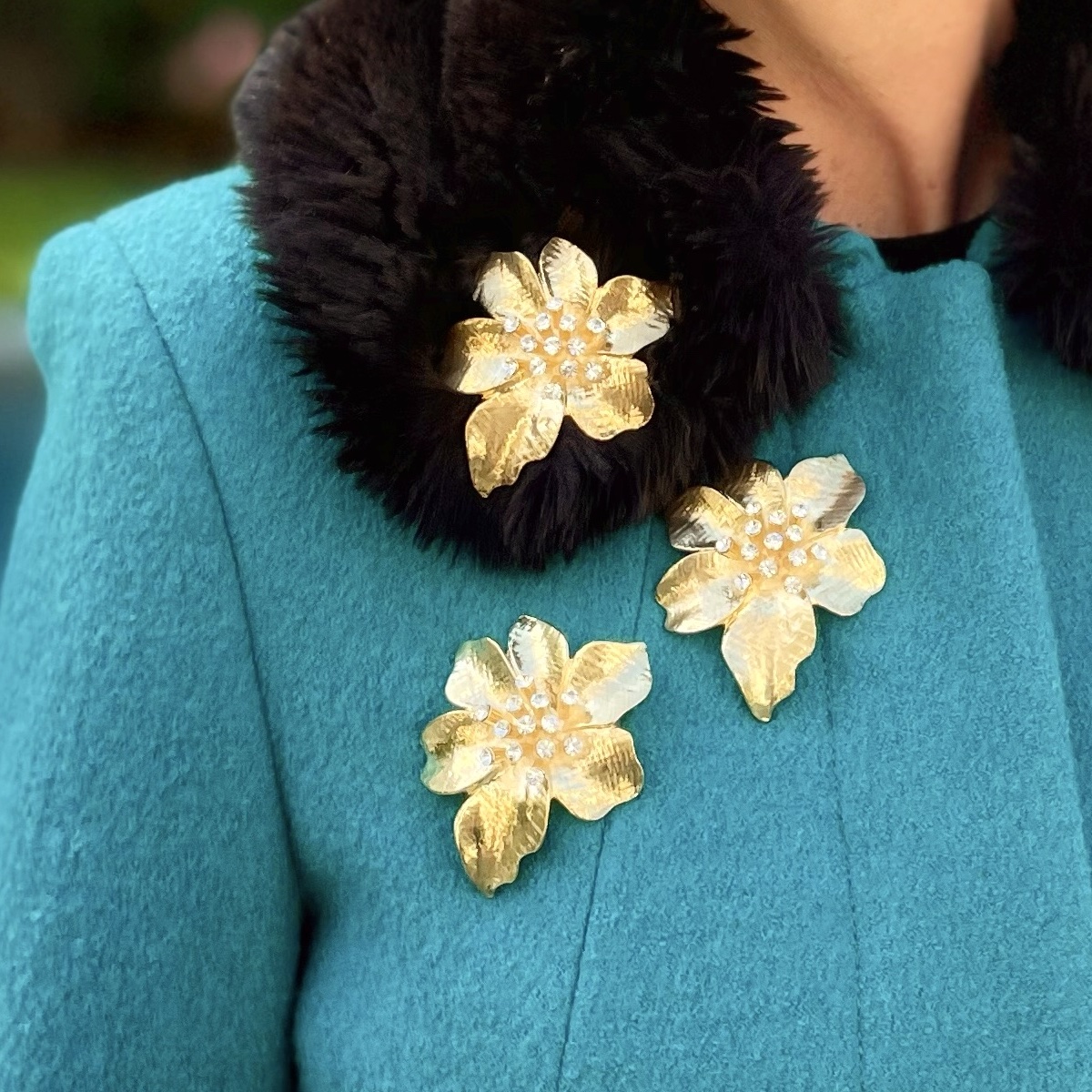 Outerwear Adornment: Gold Flower Brooches on a Teal Coat Outerwear Adornment: Gold Flower Brooches on a Teal Coat — Brooch Outfits 2027
