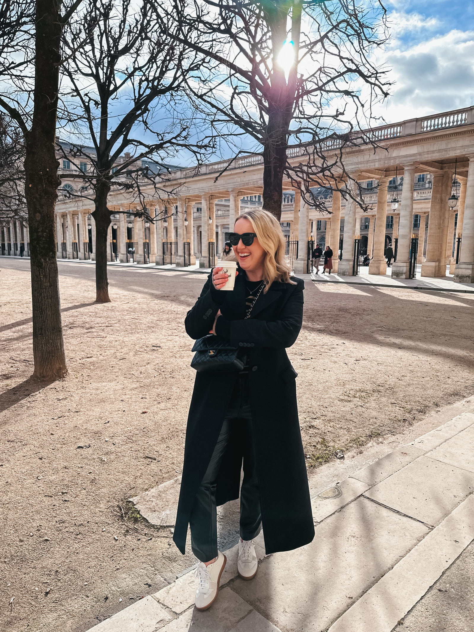 Long Black Wool Coat Over Slim Trousers And Sneakers Long Black Wool Coat Over Slim Trousers And Sneakers — Winter Dinner Outfits 2027